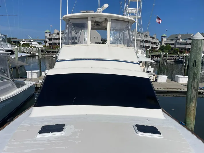 Occtane Yacht Photos Pics 1990 Ocean Yachts 44 Super Sport docked at a marina, clear blue sky background.