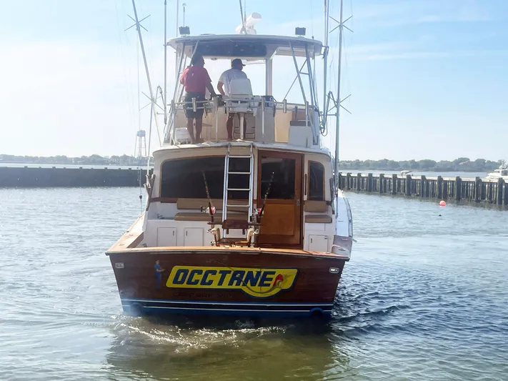 Occtane Yacht Photos Pics 1990 Ocean Yachts 44 Super Sport boat on water, rear view with two people onboard.