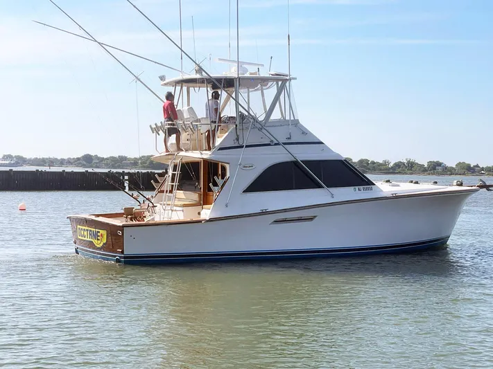 Occtane Yacht Photos Pics 1990 Ocean Yachts 44 Super Sport boat on calm water, featuring fishing rods and a flybridge.