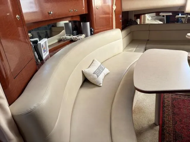  Yacht Photos Pics 2003 Sea Ray 340 Sundancer interior with curved beige seating and wooden cabinetry.