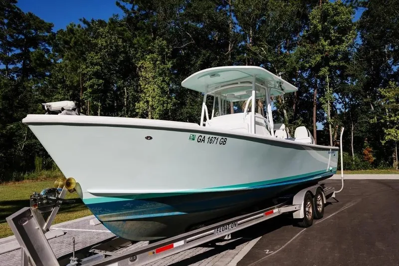  Yacht Photos Pics 2017 Albury Brothers center console boat on trailer, surrounded by trees.