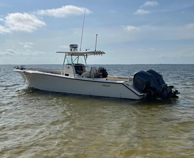 Yacht Photos Pics 2009 Pursuit 3400 Offshore boat anchored in calm waters under a clear sky.