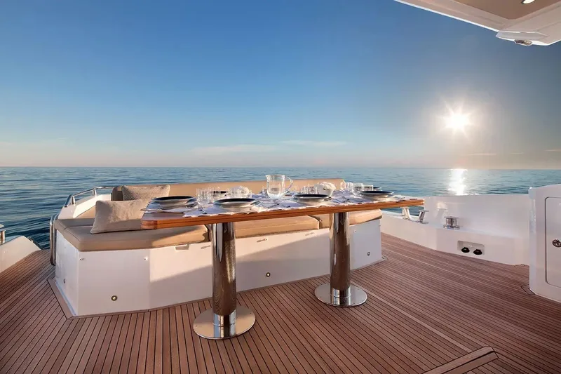  Yacht Photos Pics Luxurious Azimut 77S yacht deck with elegant dining setup, ocean view, and sunset ambiance.