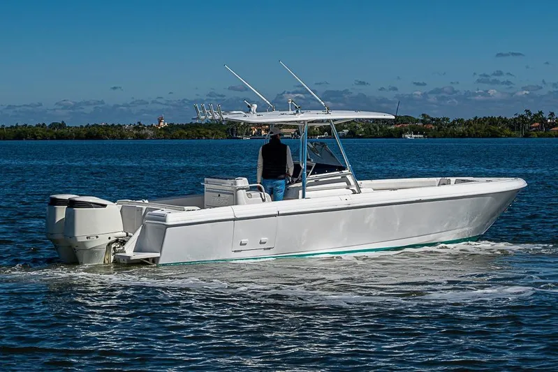  Yacht Photos Pics 2005 Intrepid 300 Center Console boat cruising on a calm, scenic waterway.