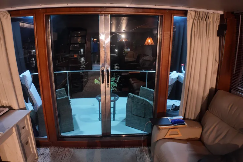  Yacht Photos Pics Interior view of 1987 Viking Gulfstar yacht with sliding glass doors and cozy seating.