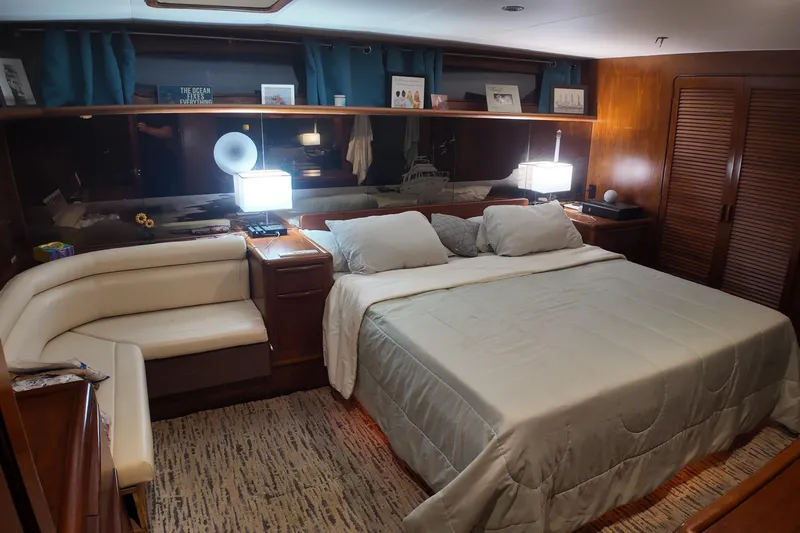  Yacht Photos Pics Luxurious 1987 Viking Gulfstar yacht bedroom with king-size bed, elegant decor, and ambient lighting.