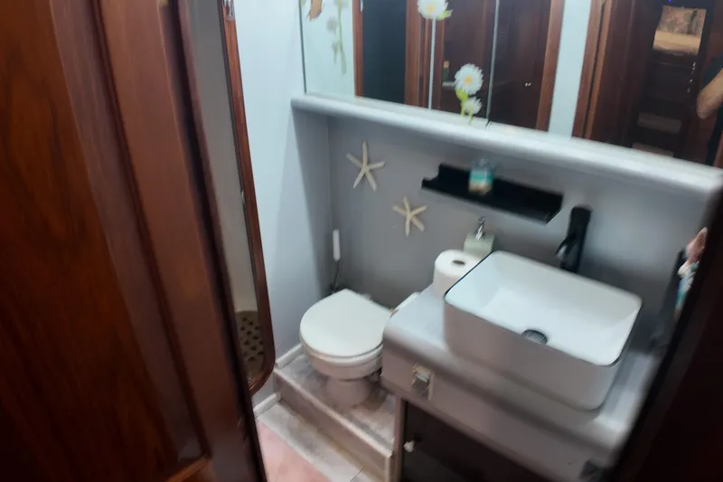  Yacht Photos Pics Compact bathroom in a 1987 Viking Gulfstar boat with modern sink and nautical decor.