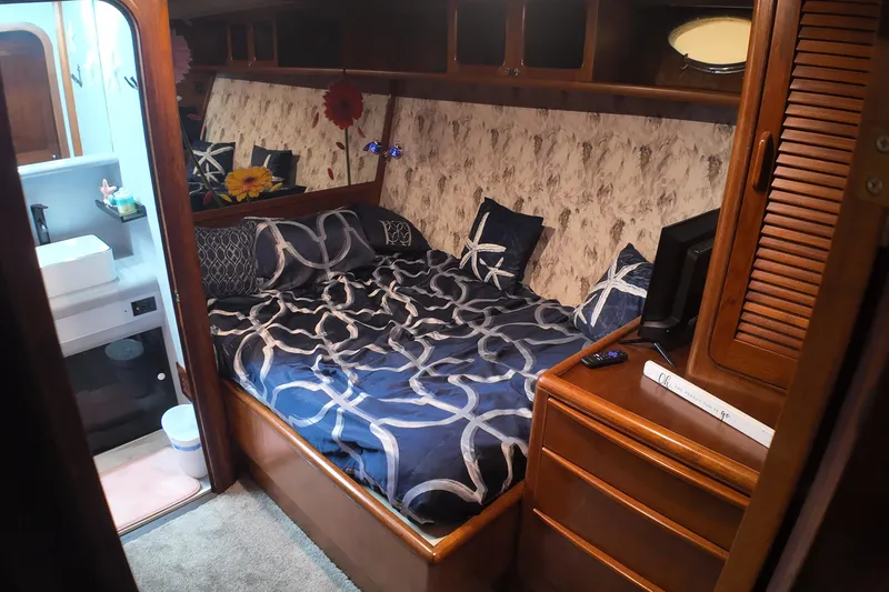  Yacht Photos Pics Cozy bedroom in 1987 Viking Gulfstar yacht with nautical-themed bedding and adjacent bathroom.