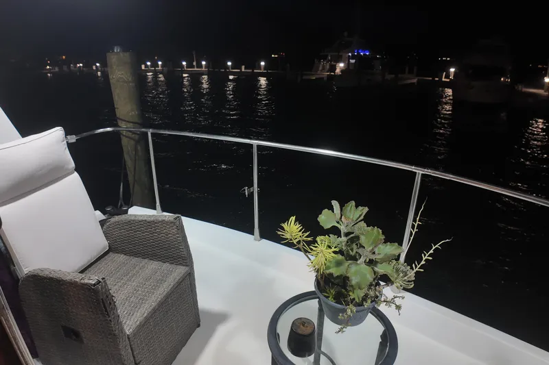  Yacht Photos Pics Cozy seating area on 1987 Viking Gulfstar yacht at night, with potted plant and waterfront view.