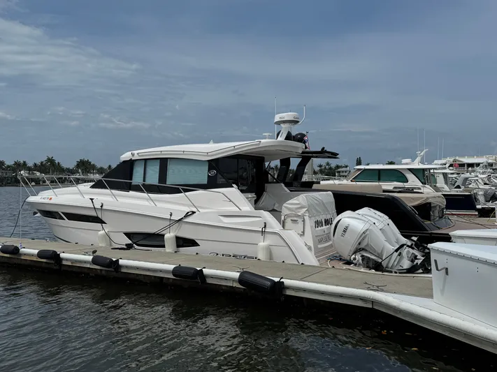 19th Hole Yacht Photos Pics 2024 Regal 38 XO yacht docked at marina under cloudy sky.