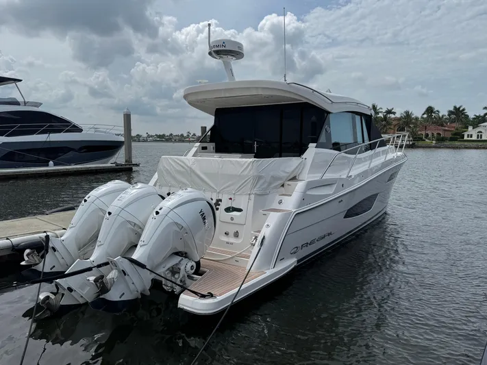 19th Hole Yacht Photos Pics 2024 Regal 38 XO yacht docked, featuring triple outboard engines, sleek design, and modern amenities.