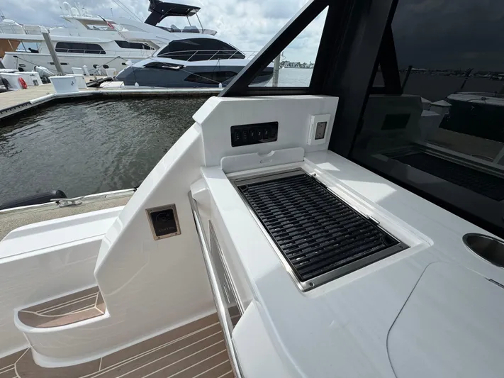 19th Hole Yacht Photos Pics 2024 Regal 38 XO yacht with outdoor grill and docked boats in background.