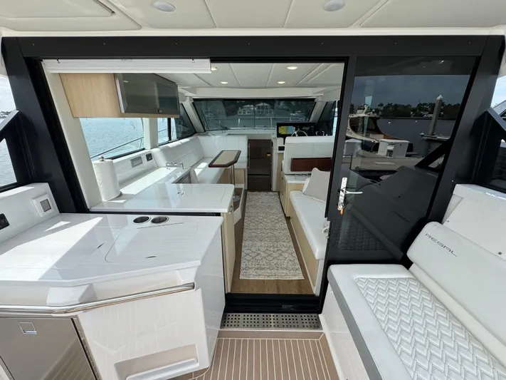19th Hole Yacht Photos Pics 2024 Regal 38 XO yacht interior with modern kitchen and seating area, featuring sleek design and waterfront view.