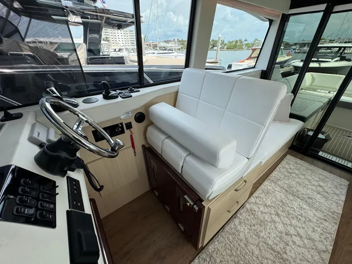 19th Hole Yacht Photos Pics 2024 Regal 38 XO yacht interior with white seating and modern helm controls.