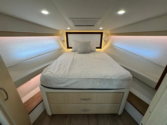 19th Hole Yacht Photos Pics Luxurious cabin interior of 2024 Regal 38 XO yacht with cozy bed and modern lighting.