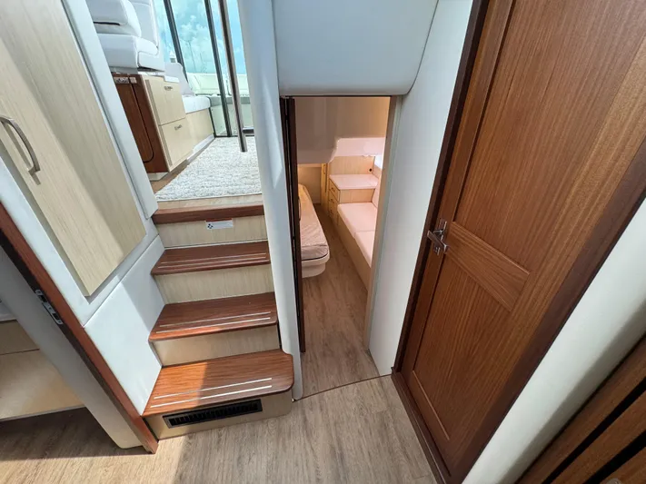 19th Hole Yacht Photos Pics 2024 Regal 38 XO yacht interior with wooden stairs and cozy cabin.
