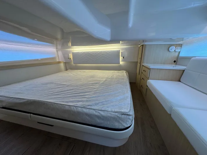 19th Hole Yacht Photos Pics 2024 Regal 38 XO cabin interior with bed, seating, and modern lighting.