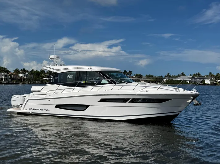 19th Hole Yacht Photos Pics 2024 Regal 38 XO yacht on calm water under a clear blue sky.