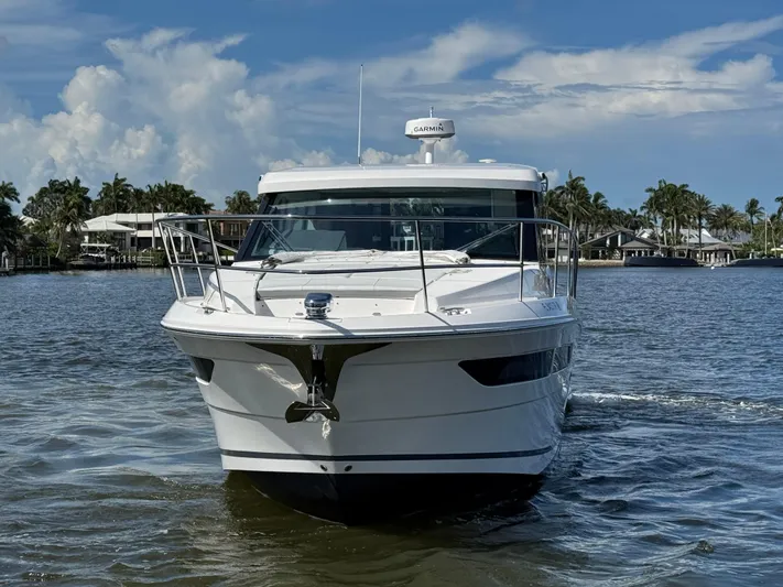 19th Hole Yacht Photos Pics 2024 Regal 38 XO yacht cruising on a sunny day, surrounded by palm trees.