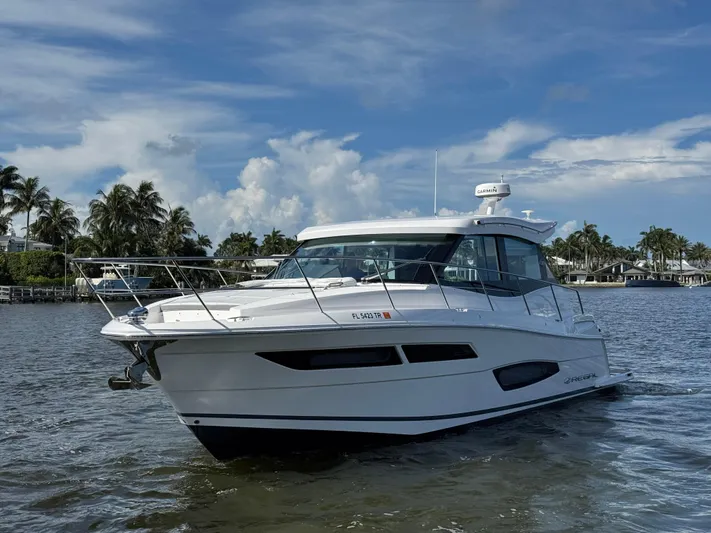 19th Hole Yacht Photos Pics 2024 Regal 38 XO yacht cruising on a sunny day with palm trees in the background.