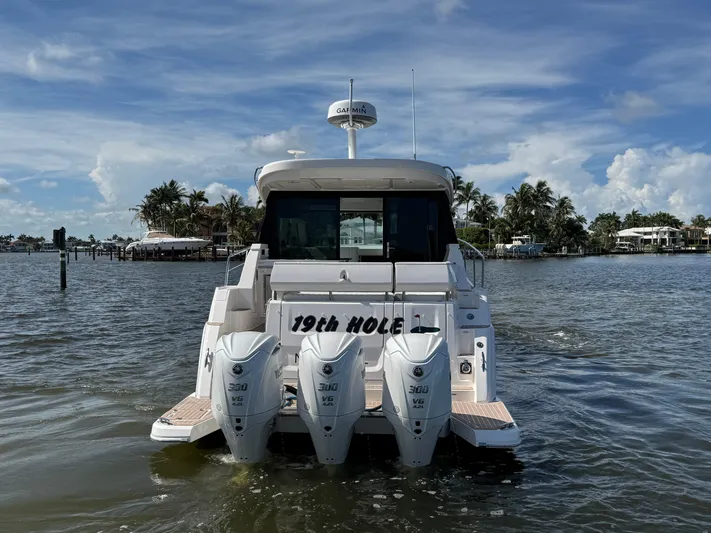 19th Hole Yacht Photos Pics 2024 Regal 38 XO boat with triple outboard engines on a sunny day.