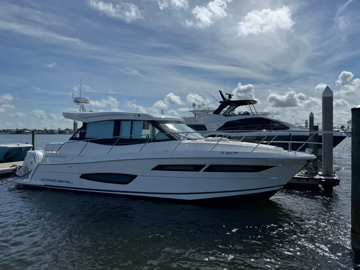 19th Hole Yacht Photos Pics 2024 Regal 38 XO yacht docked under a partly cloudy sky.