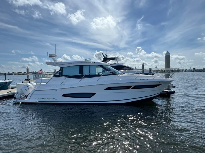 19th Hole Yacht Photos Pics 2024 Regal 38 XO yacht docked on a sunny day with a scenic water backdrop.