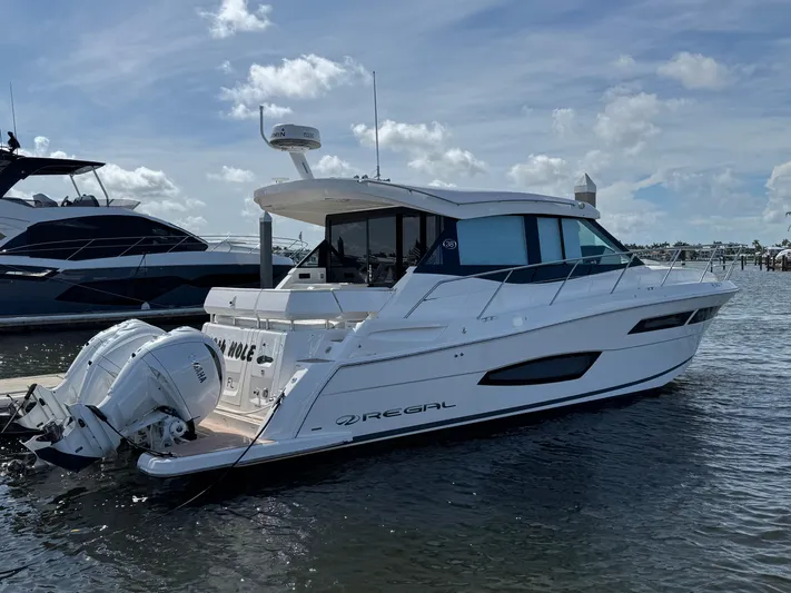 19th Hole Yacht Photos Pics 2024 Regal 38 XO luxury yacht docked on a sunny day, showcasing sleek design and powerful engines.