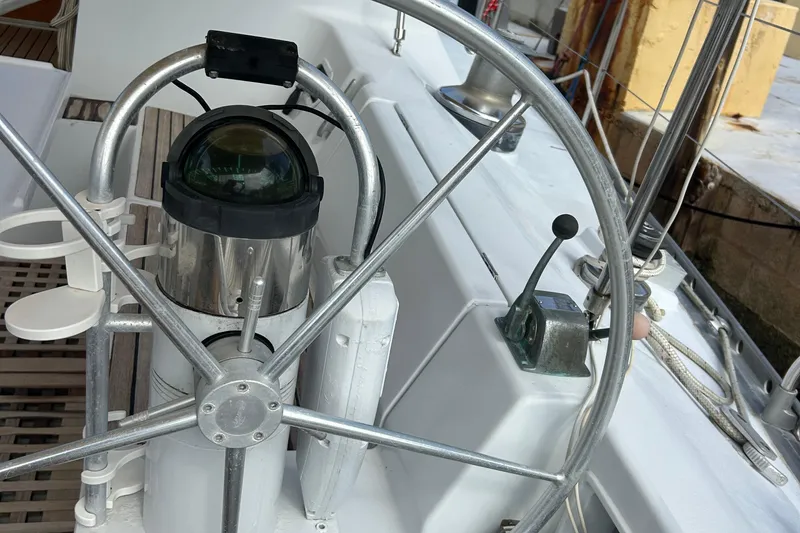 Zephyrus Yacht Photos Pics Steering wheel and compass on a 1991 Beneteau 500 Oceanis sailboat.