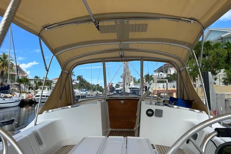 Zephyrus Yacht Photos Pics 1991 Beneteau 500 Oceanis sailboat cockpit with canopy, docked in a marina.