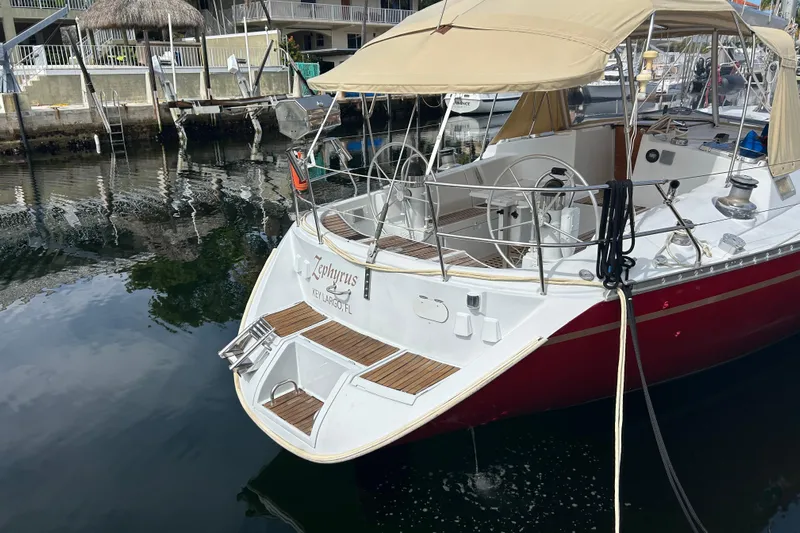 Zephyrus Yacht Photos Pics 1991 Beneteau 500 Oceanis sailboat docked, featuring a red hull and beige canopy.