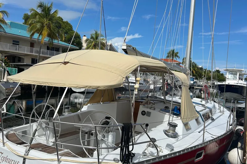 Zephyrus Yacht Photos Pics 1991 Beneteau 500 Oceanis sailboat docked, featuring a beige canopy and tropical surroundings.