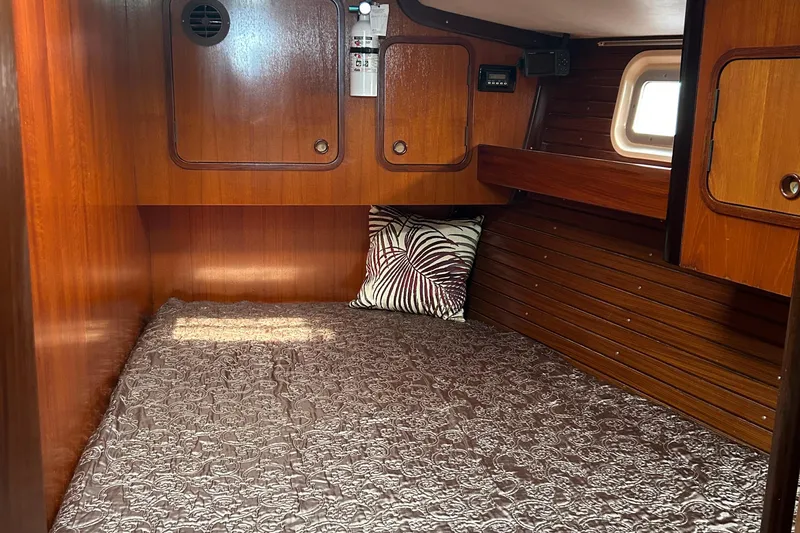 Zephyrus Yacht Photos Pics Cozy cabin interior of 1991 Beneteau 500 Oceanis sailboat with wood paneling and bedding.