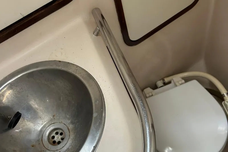 Zephyrus Yacht Photos Pics 1991 Beneteau 500 Oceanis bathroom with metal sink and toilet.