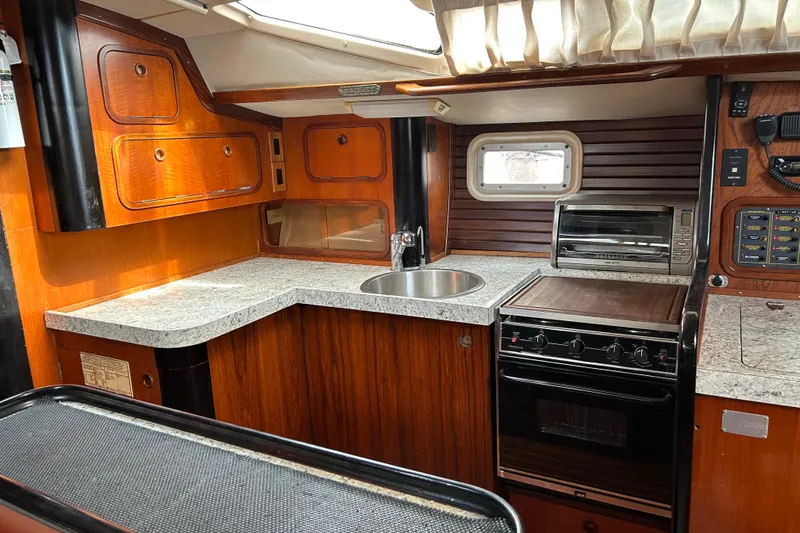 Zephyrus Yacht Photos Pics Interior of 1991 Beneteau 500 Oceanis yacht kitchen with wood cabinetry and modern appliances.