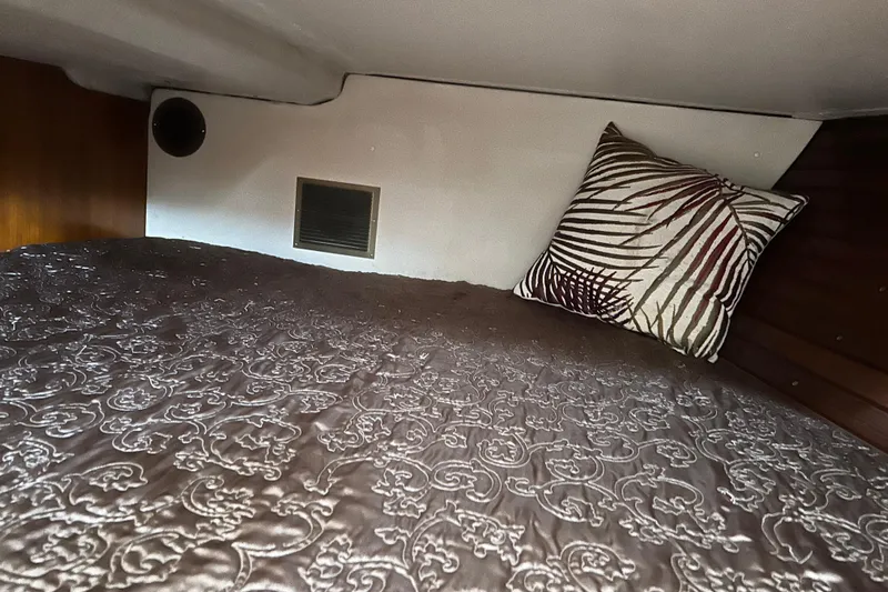 Zephyrus Yacht Photos Pics Cozy cabin interior of 1991 Beneteau 500 Oceanis with patterned bedding and decorative pillow.