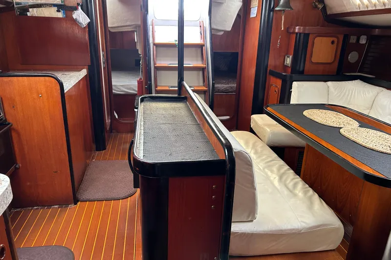 Zephyrus Yacht Photos Pics Interior of 1991 Beneteau 500 Oceanis yacht with wood finish and white seating.