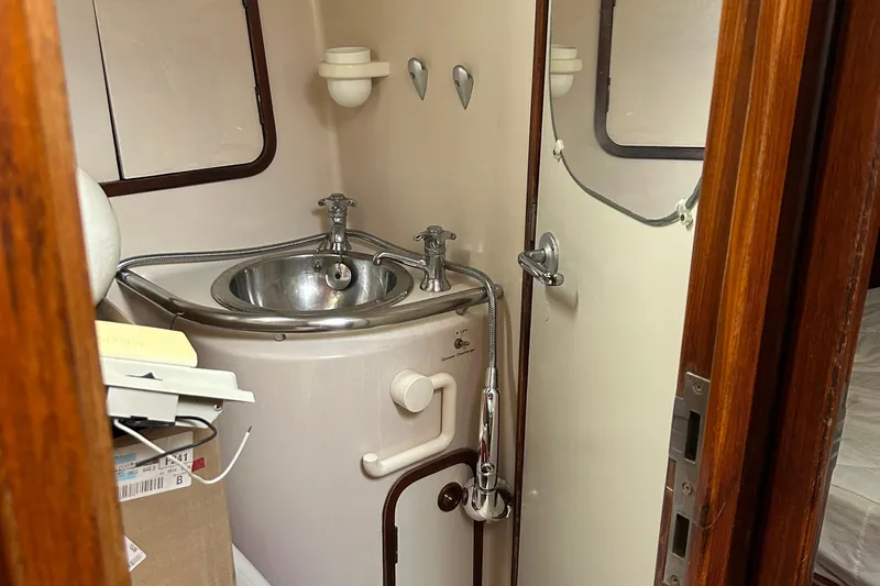 Zephyrus Yacht Photos Pics Compact bathroom in a 1991 Beneteau 500 Oceanis yacht with stainless steel sink.