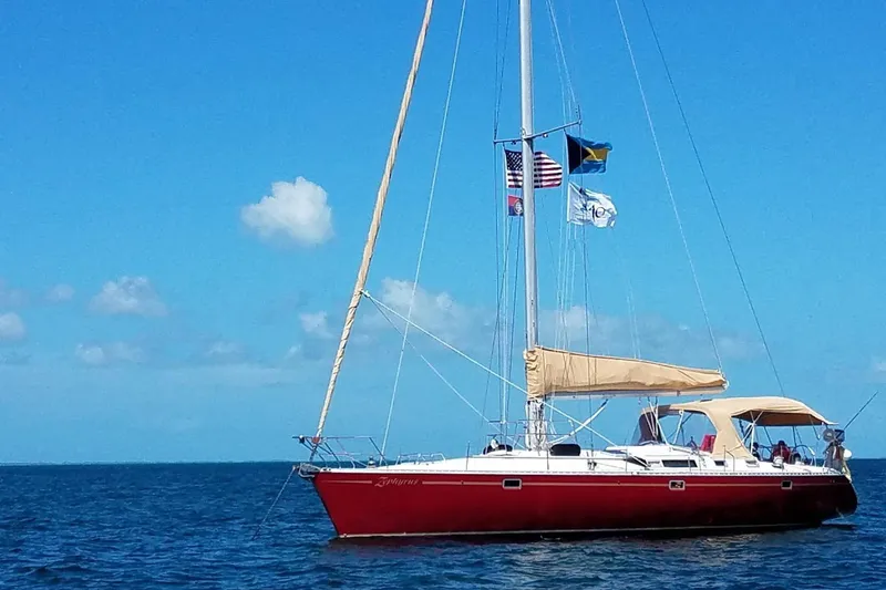 Zephyrus Yacht Photos Pics Red 1991 Beneteau 500 Oceanis sailboat on open sea under clear blue sky.