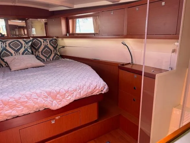Laguna D Yacht Photos Pics Luxurious bedroom interior of 2013 Beneteau 48 yacht with wooden cabinetry and cozy bedding.