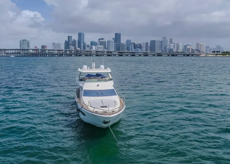 Thinks It's His Too Yacht Photos Pics Luxury 2008 Azimut Flybridge yacht anchored with city skyline backdrop.