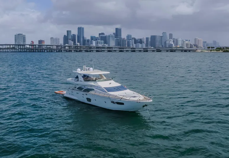 Thinks It's His Too Yacht Photos Pics Luxury 2008 Azimut Flybridge yacht on water with city skyline backdrop.