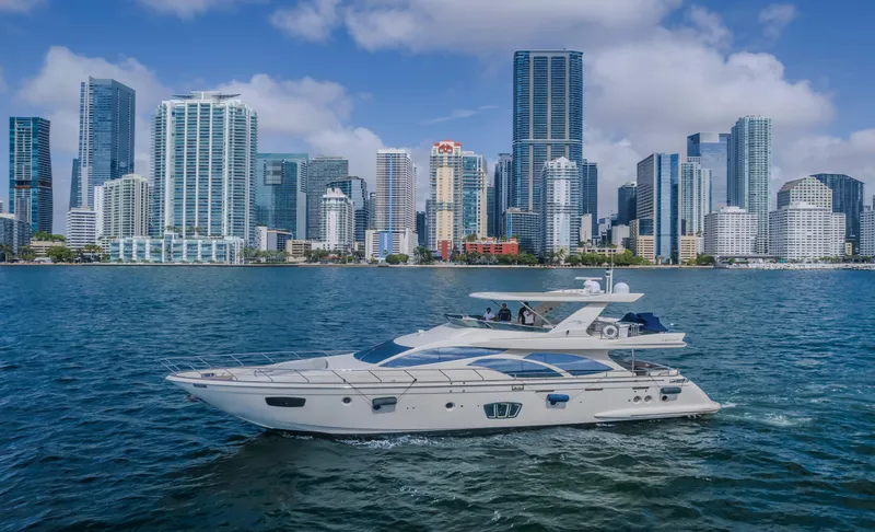 Thinks It's His Too Yacht Photos Pics 2008 Azimut Flybridge yacht cruising near a city skyline on a sunny day.