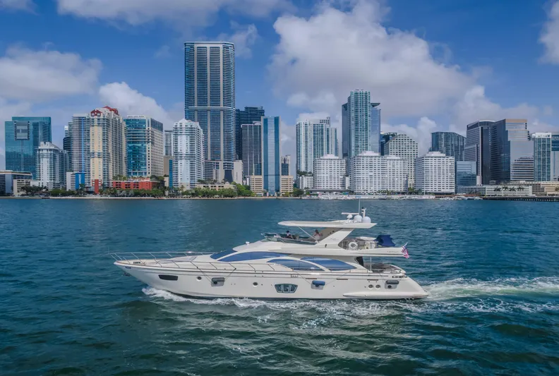 Thinks It's His Too Yacht Photos Pics 2008 Azimut Flybridge yacht cruising near a city skyline with modern skyscrapers.