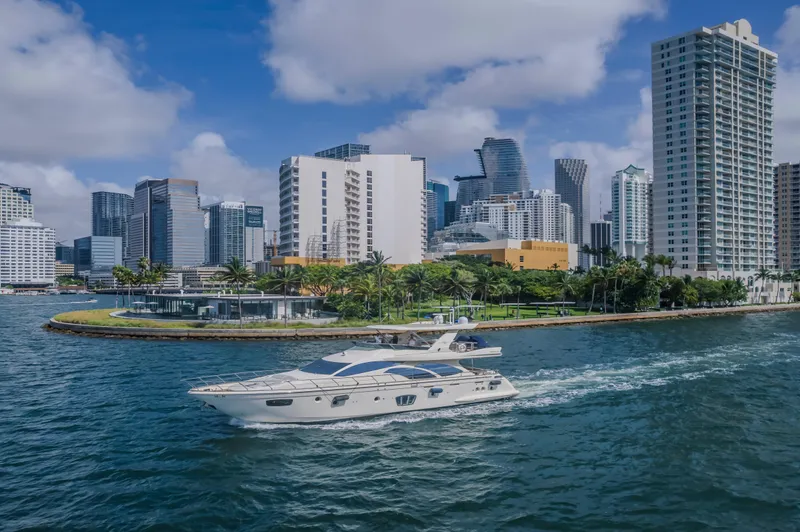 Thinks It's His Too Yacht Photos Pics 2008 Azimut Flybridge yacht cruising near a city skyline with modern skyscrapers.