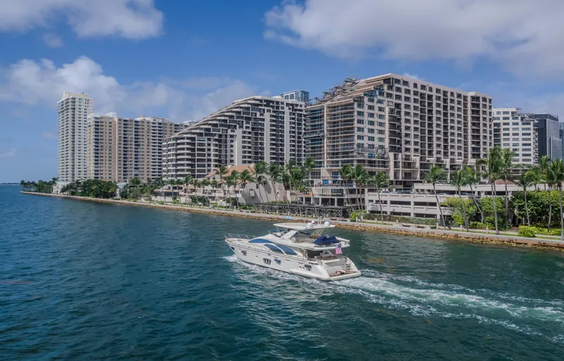 Thinks It's His Too Yacht Photos Pics 2008 Azimut Flybridge yacht cruising near waterfront cityscape with modern high-rise buildings.