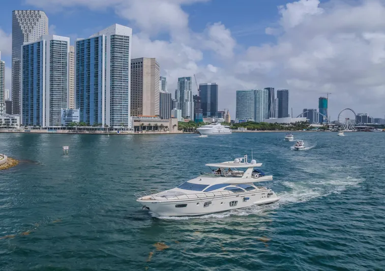 Thinks It's His Too Yacht Photos Pics 2008 Azimut Flybridge yacht cruising near city skyline with skyscrapers and Ferris wheel.