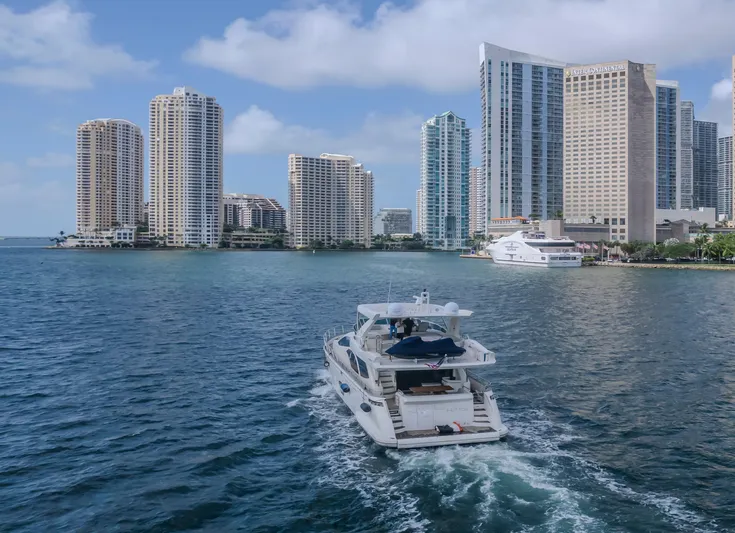 Thinks It's His Too Yacht Photos Pics Azimut Flybridge 2008 yacht cruising near city skyline and waterfront buildings.