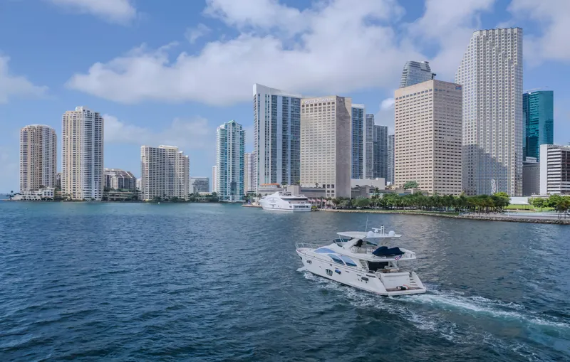 Thinks It's His Too Yacht Photos Pics Azimut Flybridge 2008 yacht cruising near city skyline with skyscrapers and blue sky.