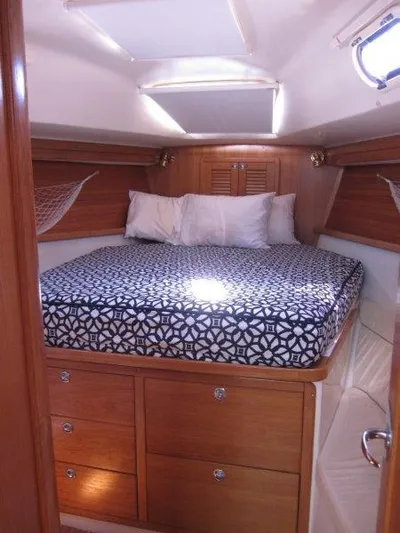  Yacht Photos Pics 2007 Catalina MkII cozy cabin with bed, wooden drawers, and porthole window.